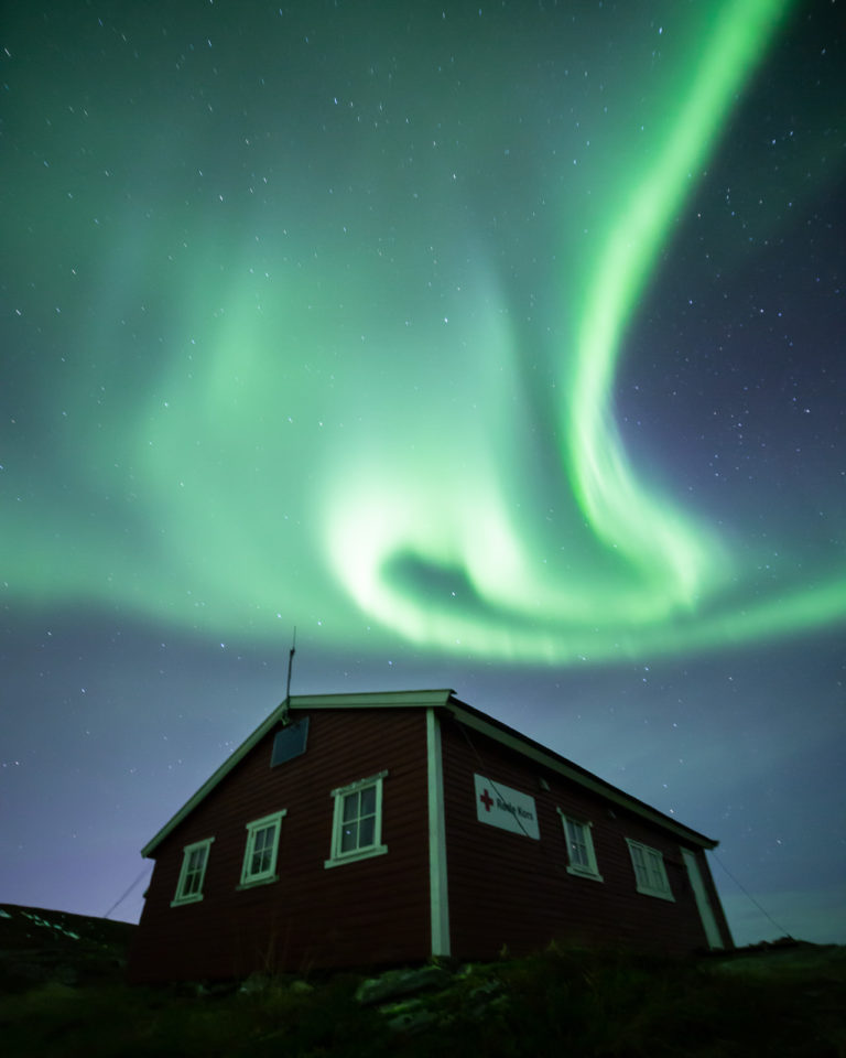 En virvel av nordlys over hytta © William Copeland