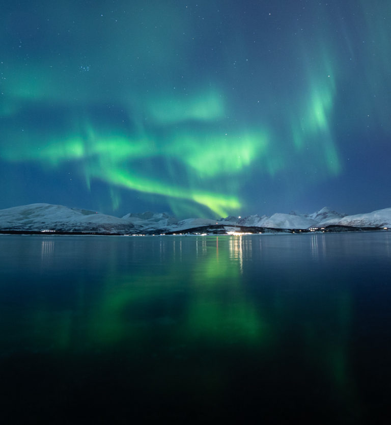 Fjellene i silhuett mot nordlyset langt der ute i vest © William Copeland