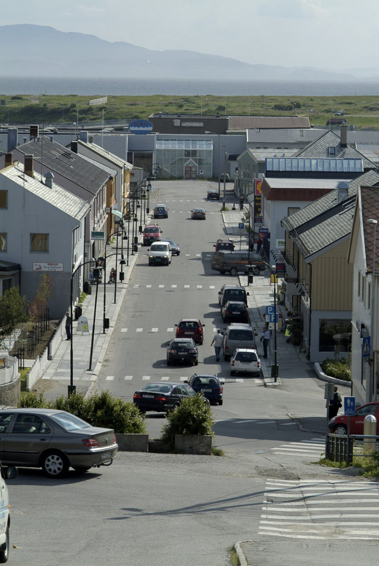 Hovedgata i Vadsø, sett fra kirkebakken, med forretningsgårder i gjenreisningsstil langs sidene. Kjøpesenteret i enden er nyere © Trym Ivar Bergsmo