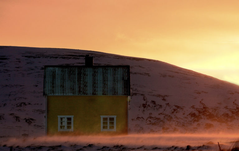 Anne Olsen-Ryum tar bilder av de fargerike, enkle gjenreisingshusene i det nakne landskapet på Sørøya © Anne Olsen-Ryum
