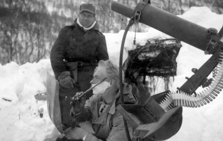 Fjellkrigen. Hygiene er viktig, også i felt. EN soldat fra IR15 trimmer skjegget ved en Colt mitraljøse.Stor oversikt over slaget om Narvik inne Narvik Krigsmuseum. Kampene foregikk rundt Ofotfjorden og inn i Sør-Troms  © Narvik Krigsmuseum