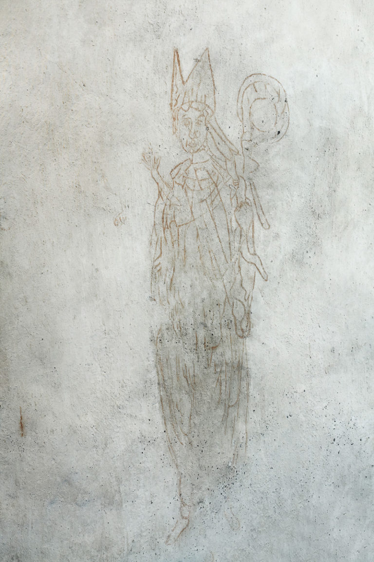 Denne biskopen er malt på kirkeveggen på 1400-tallet. Den gang hadde det sterke farger. Disse er gjenskapt på Trondenes historiske senter, men denne originalen har bleknet de siste 600 årene © Yvonne Holth/www.nordnorge.com