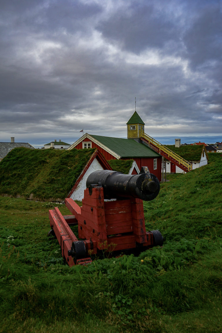A gun on the rampart, and the old houses in the yard at Vardøhus, the world's northernmost historic fortress © Katelin Pell