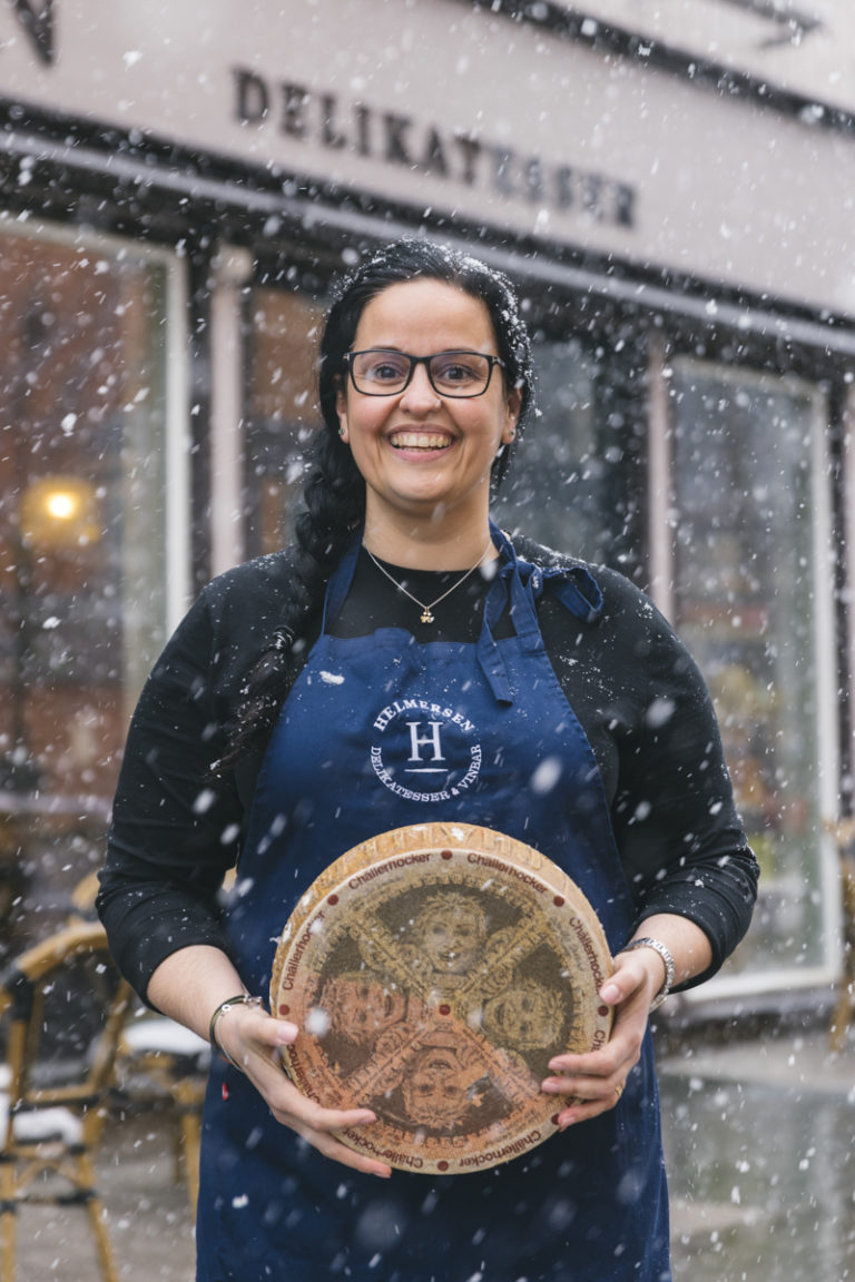 Tatjana fra Rio selger italiensk ost på tromsøværing i nordnorsk snøvær. Kom inn! © Marius Fiskum/Helmersen