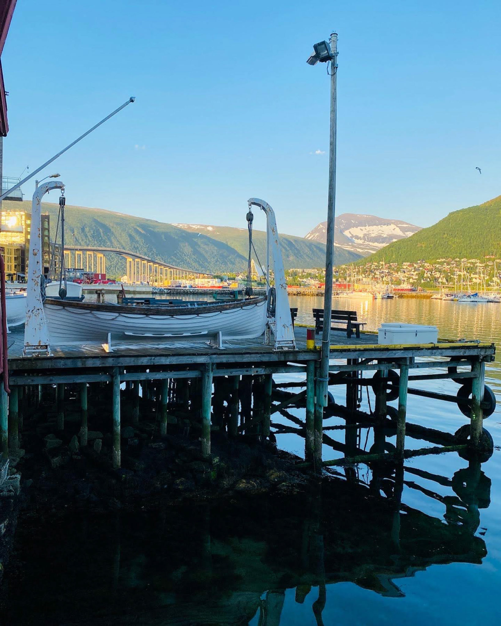 The dock of the Polar Museum in Tromsø, the Tromsø bridge and Mount Tromsdalstind, late in the evening © Knut Hansvold
