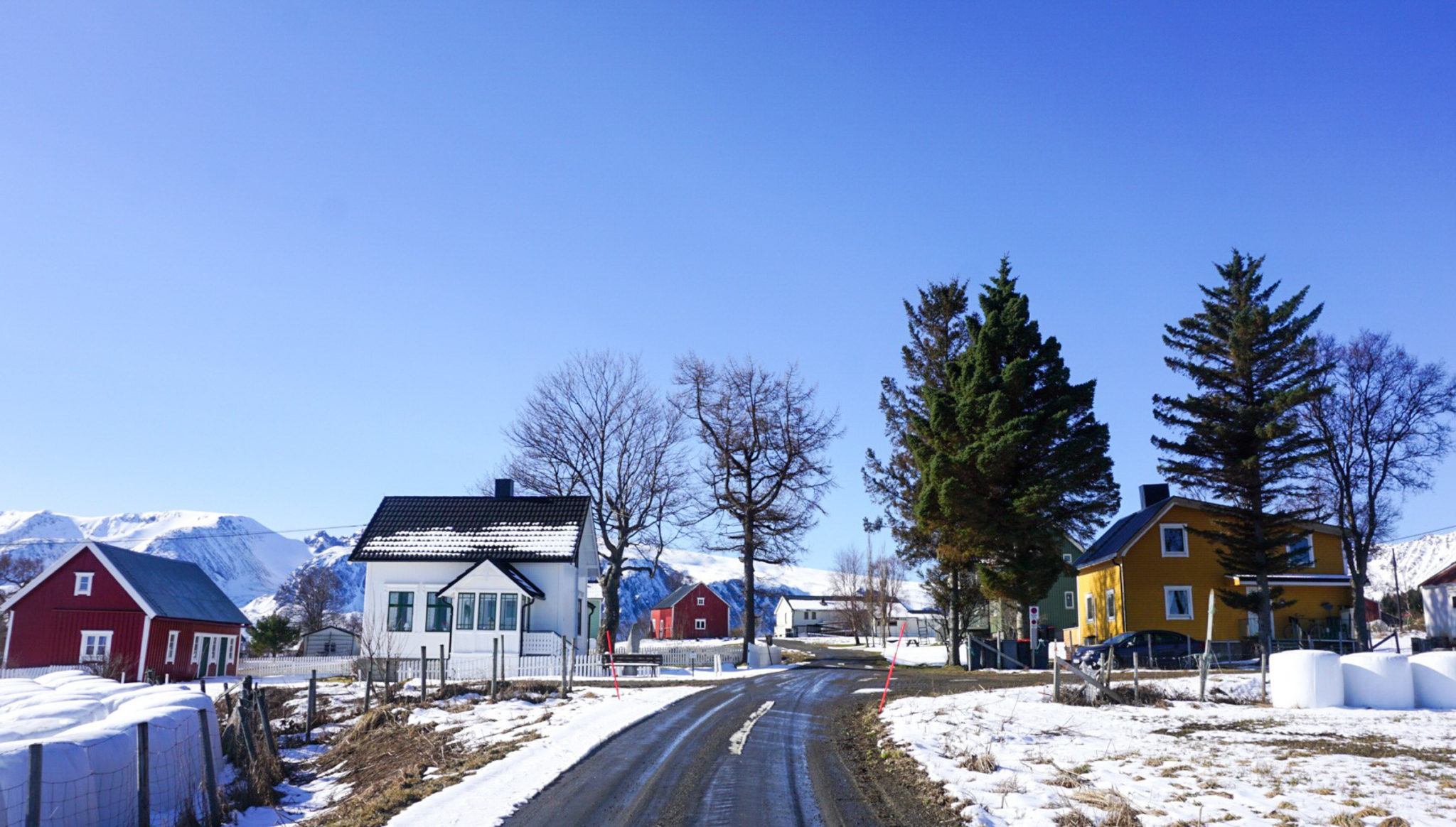 Spring snow makes the house colours pop. Pila - the arrow - an iron age standing stone is found in front of the white house with the nice glass veranda © Knut Hansvold