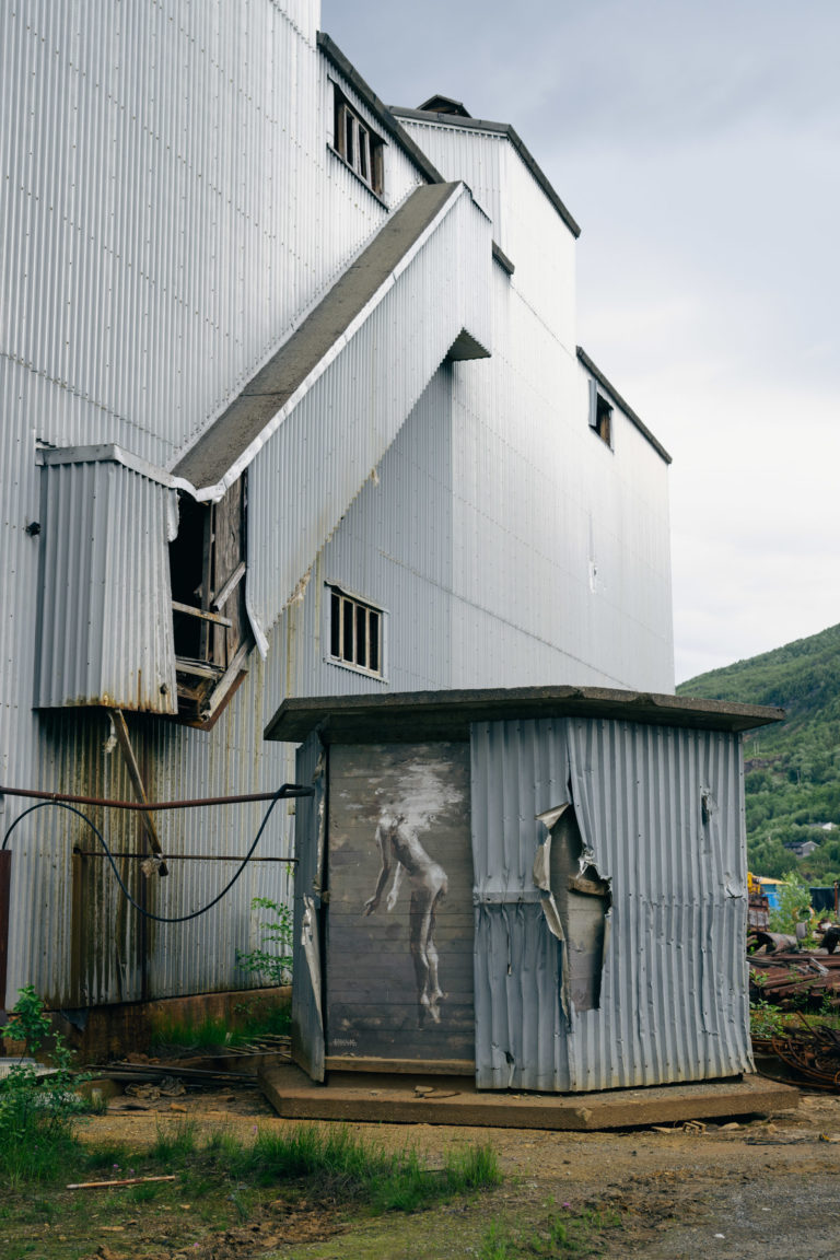 Bølgeblikkvegg med rust i skjøtene, samt et overraskende stykke street art © Marie Nystad Helgesen