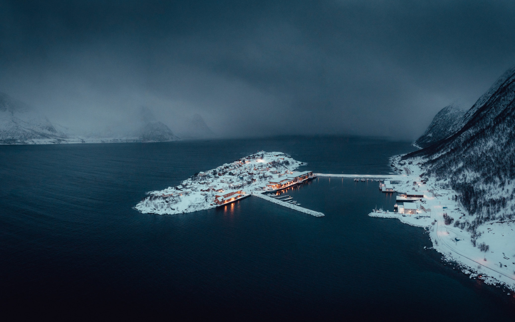 Lights in the houses at Husøya island as the snow showers arrive. Husøya is busy with fishing all winter © Steffen Fossbakk
