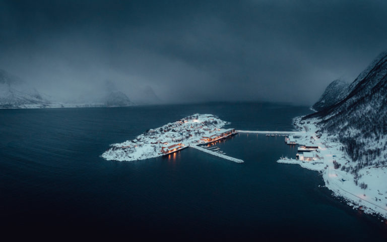 Lights in the houses at Husøya island as the snow showers arrive. Husøya is busy with fishing all winter © Steffen Fossbakk