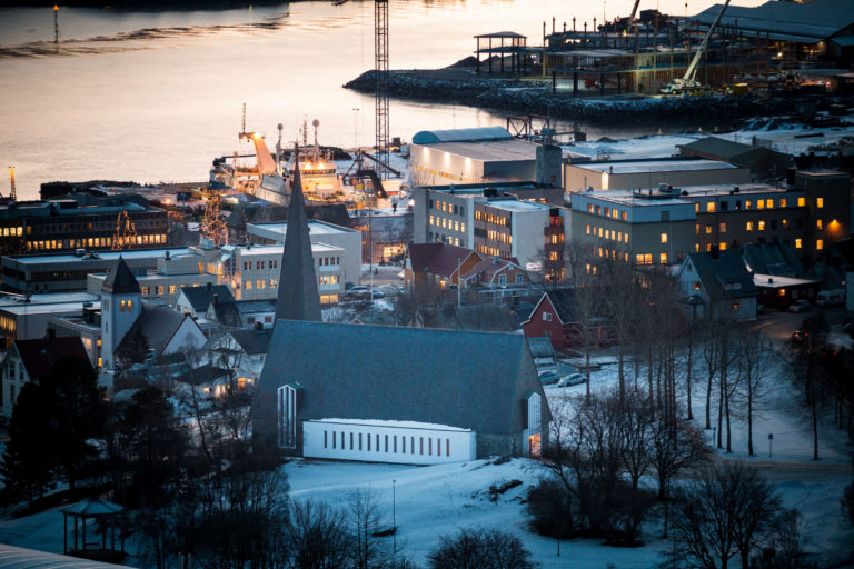 Harstad kirke fra 1958, sentrum med hele kvarterer av hus fra forrige århundreskifte og mer moderne bygg ned mot den travle havna © Øivind Arvola / Harstad kommune