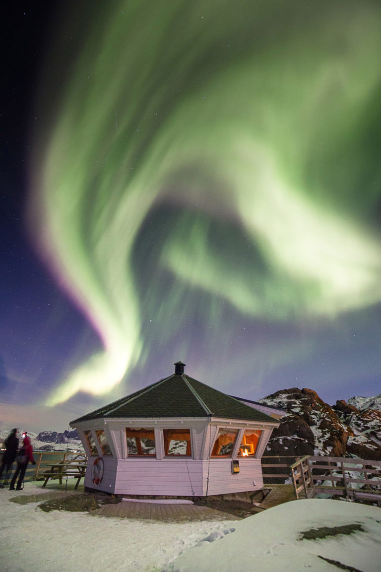 A strong Northern Lights eruption over the lighthouse at Hamn i Senja © Hamn i Senja