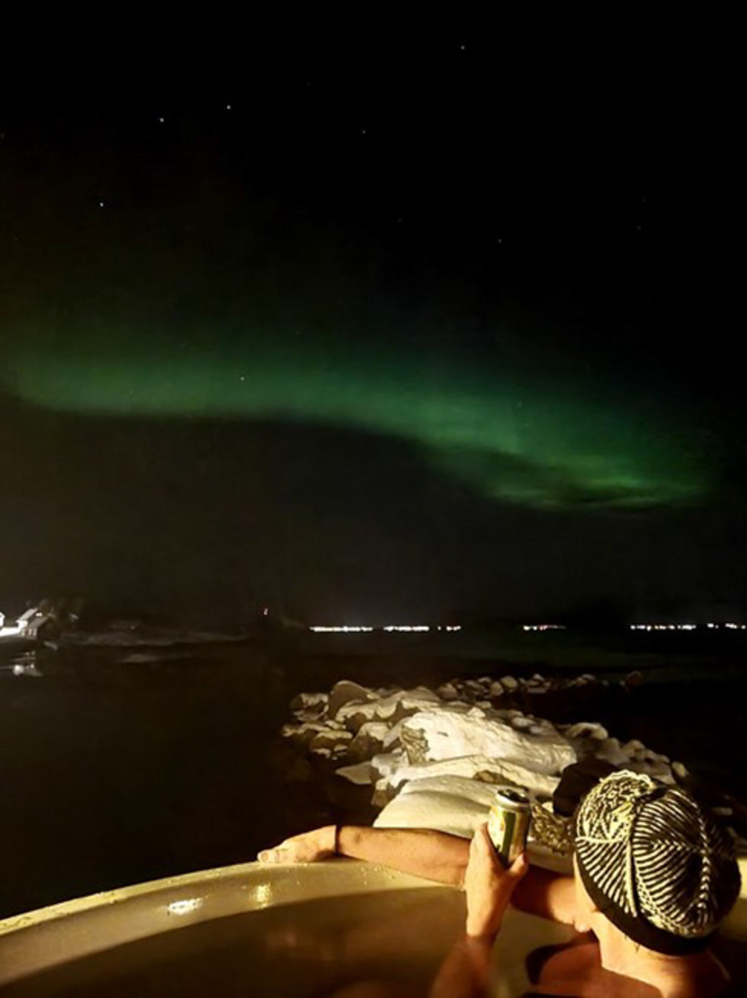 The Northern Lights playing with the clouds in the north west, and from the hot tub in Laukvik, you get the whole show © GoSenja