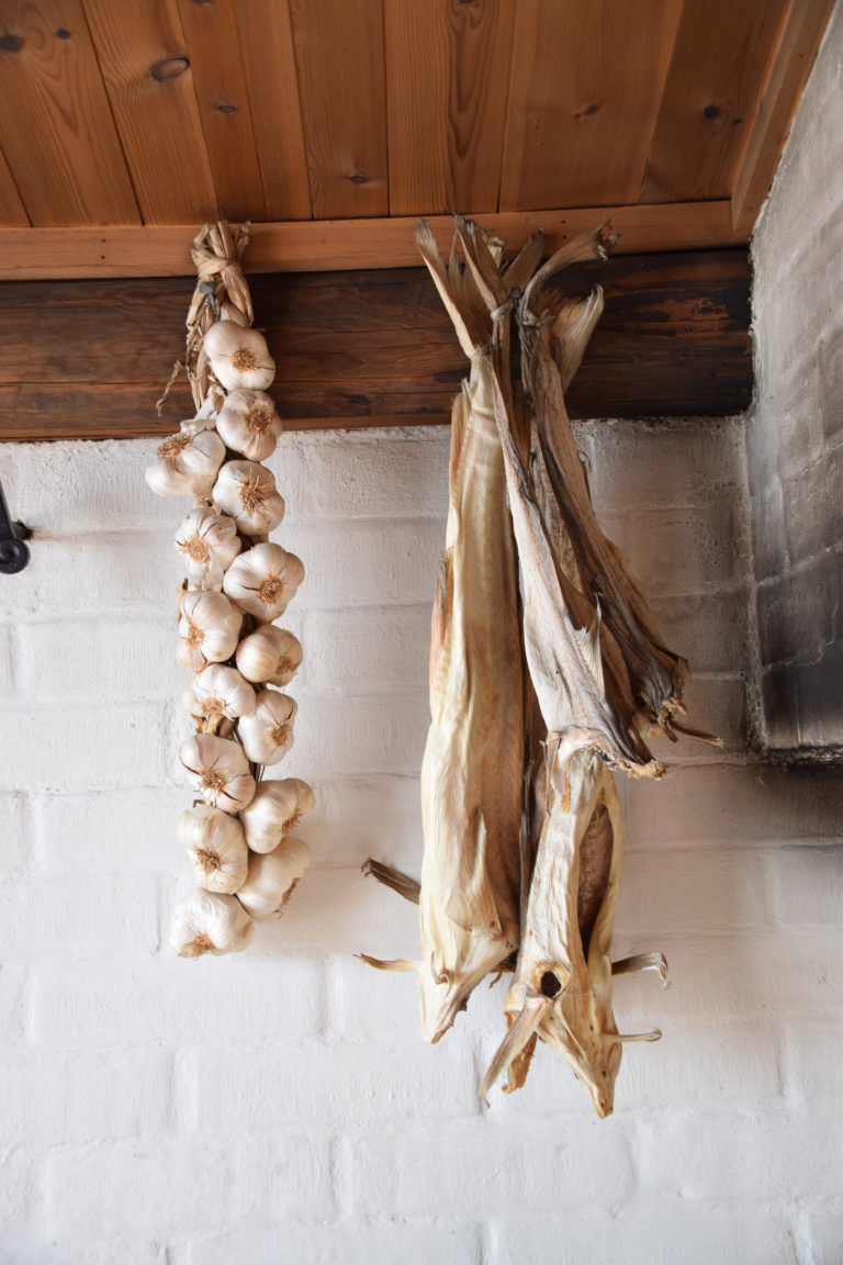Stockfisch und Knoblauch hängen bereit zum Kochen auf Holmen auf den Lofoten. Foto: Mari Bareksten